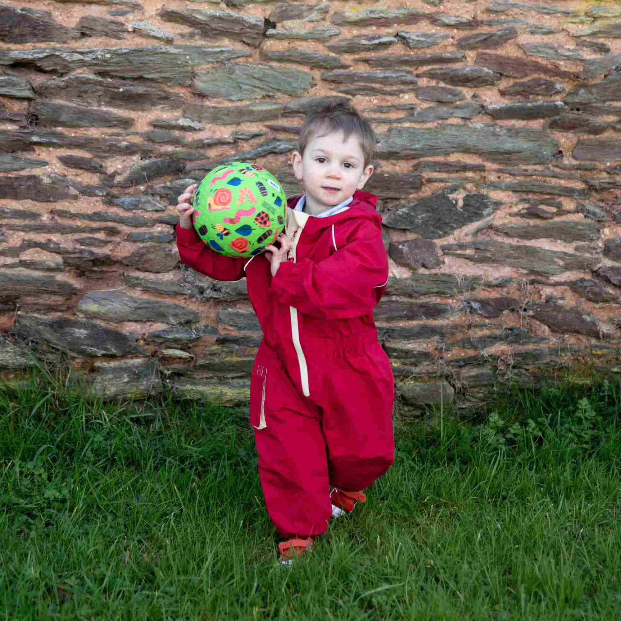 HC 24 -424 RESIZED Little boy playing with a ball in a Fiesta Red Waterproof Suit