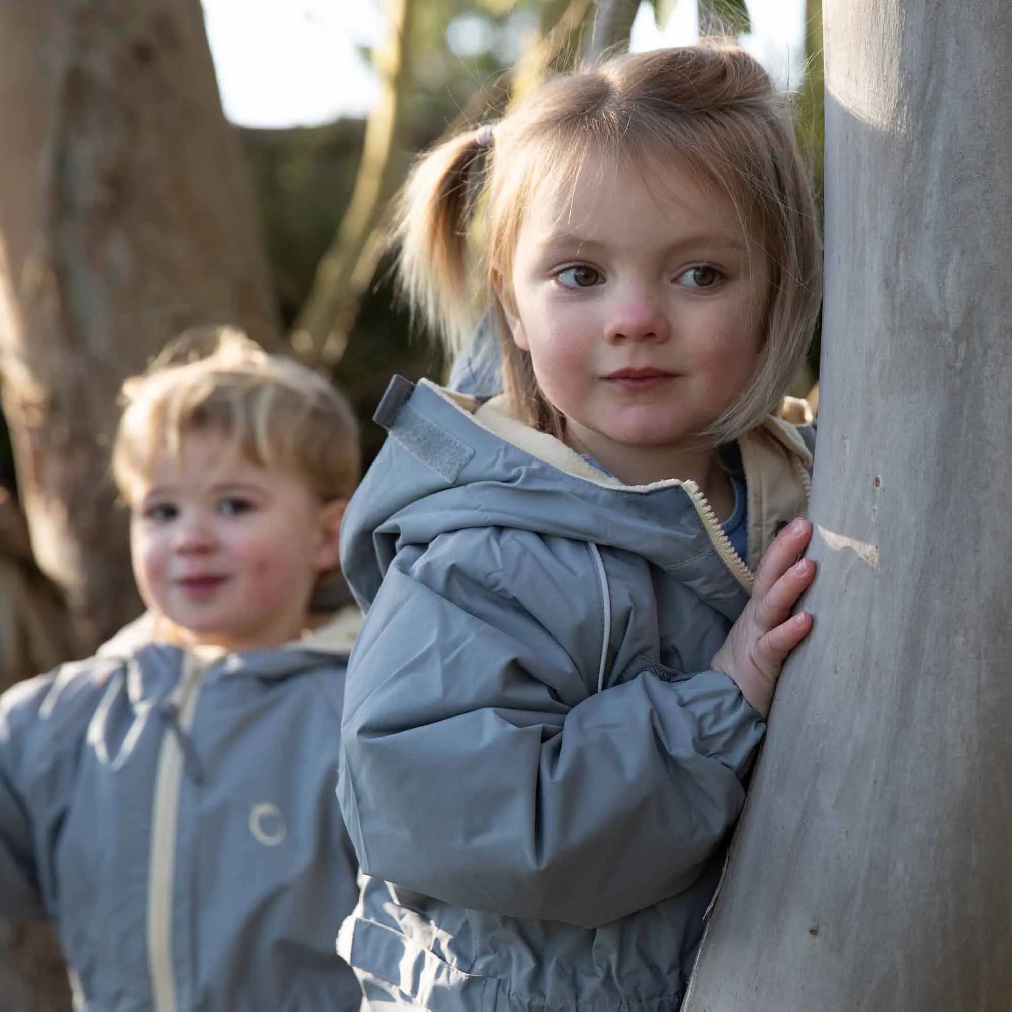Boy and girl playing in their Cool grey Fleece Lined Suits on a Tree