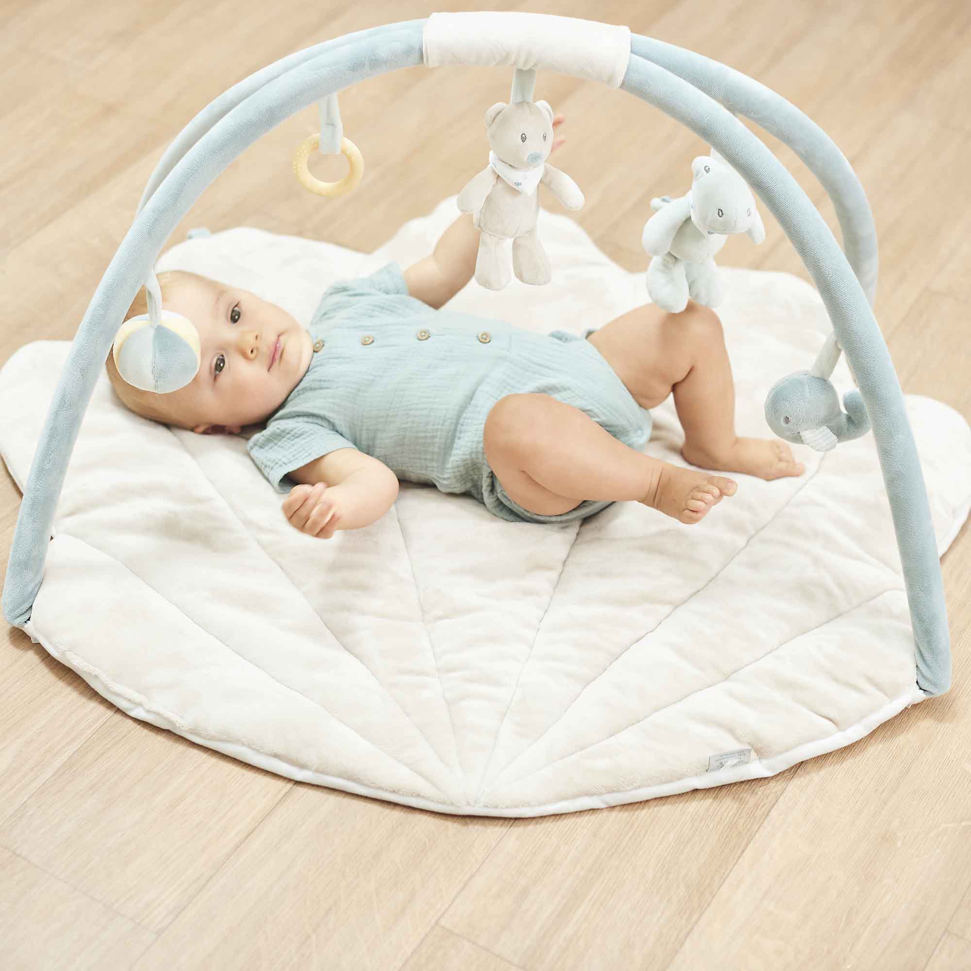 Baby lying underneath the Romeo, Jules and Sally Playmat
