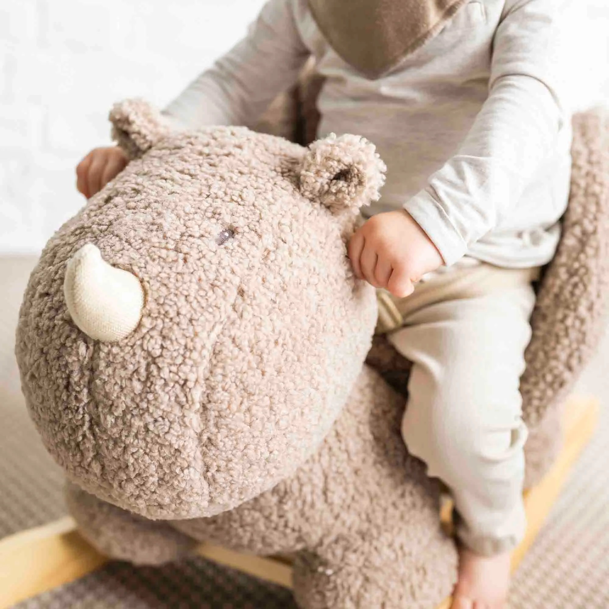 Child sitting on the Rhino Teddy Rocker, close up of rhino's face