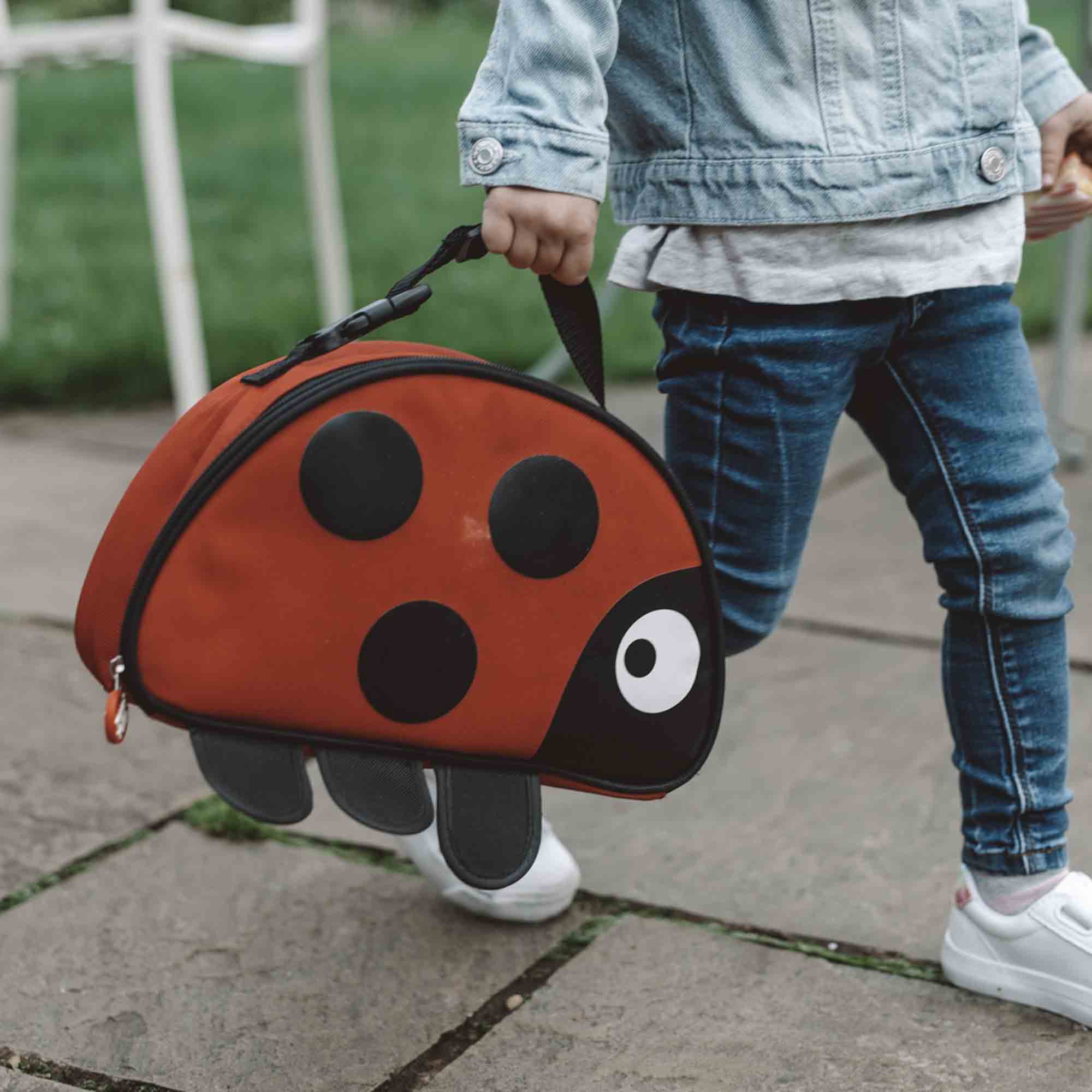 Child carrying the ladybird lunch bag