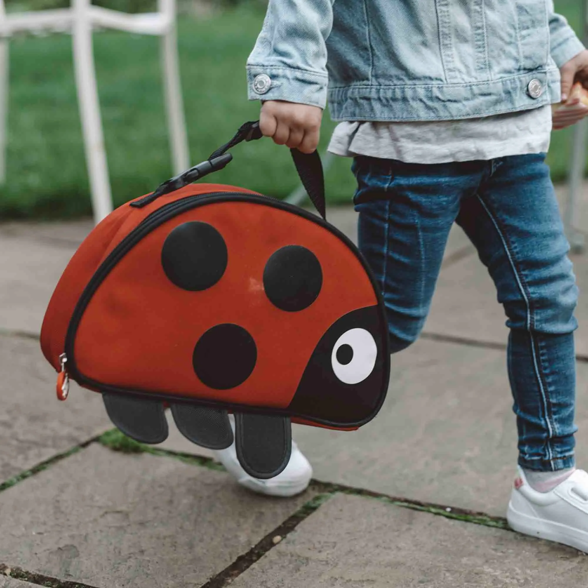 Child carrying the ladybird lunch bag