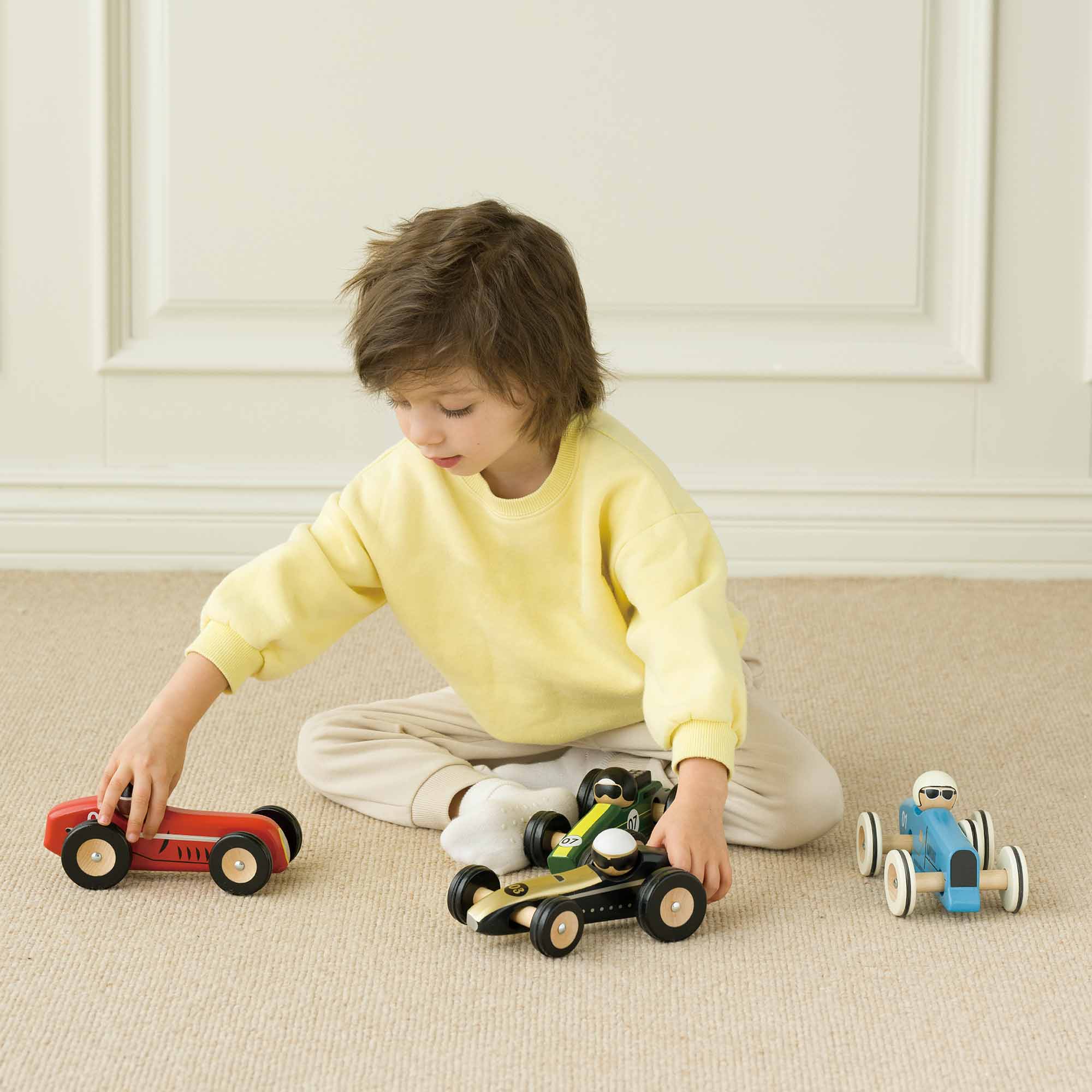 Little boy playing with collection of cars