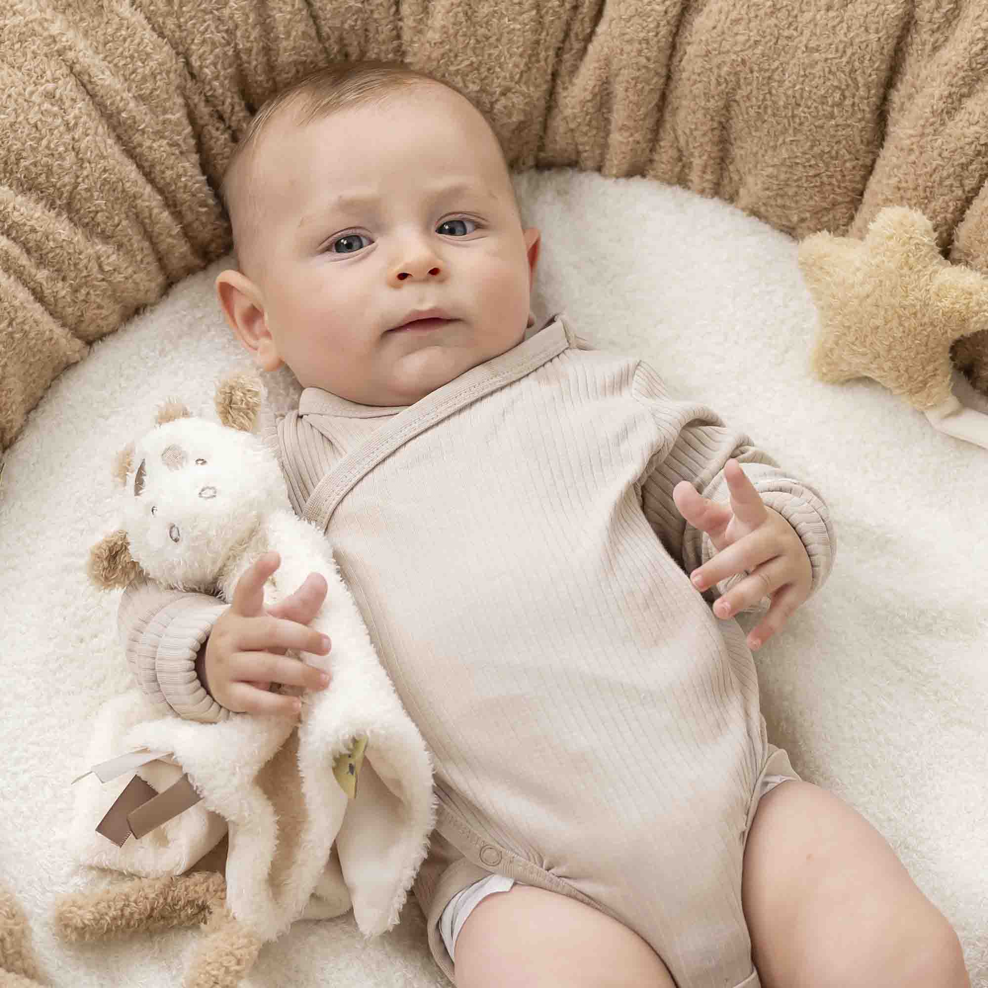Baby holding Giraffe Doudou