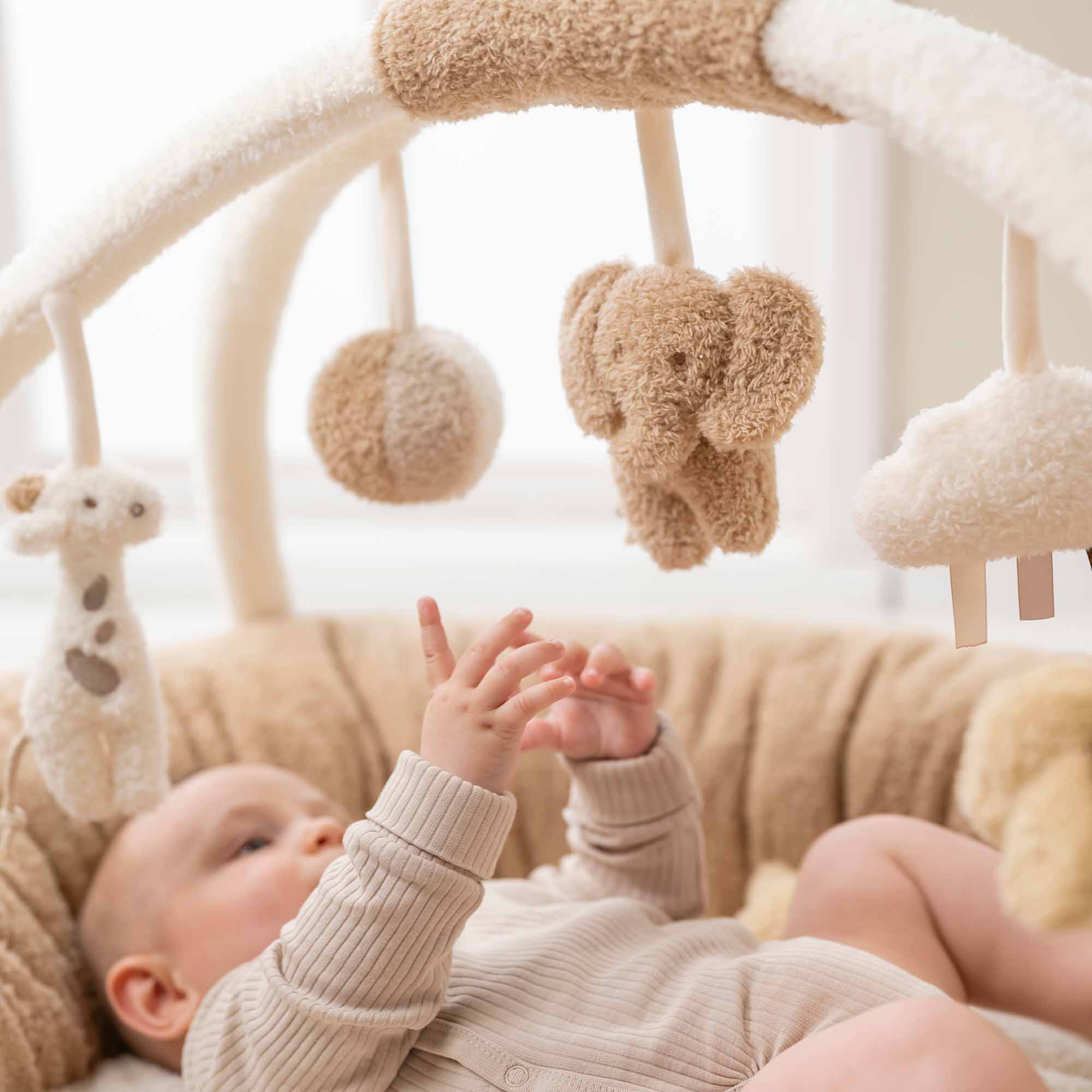 Baby playing with Stuffed teddy playmat with arches