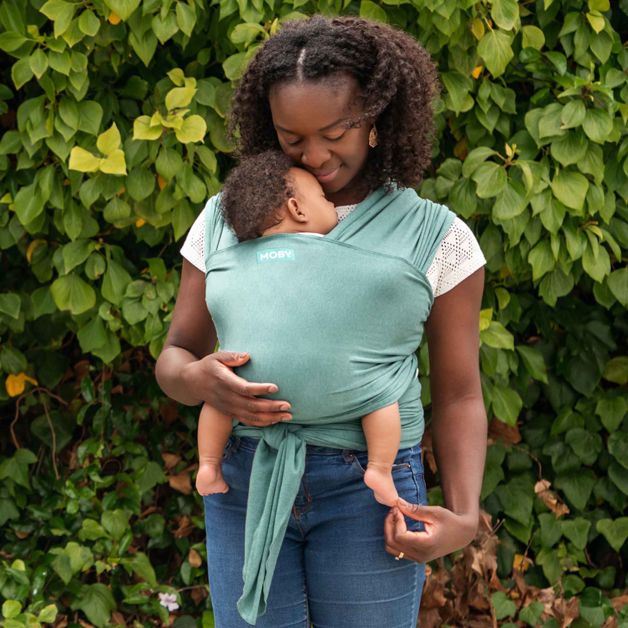 Mother carrying baby in Moby Elements Hydro Wrap