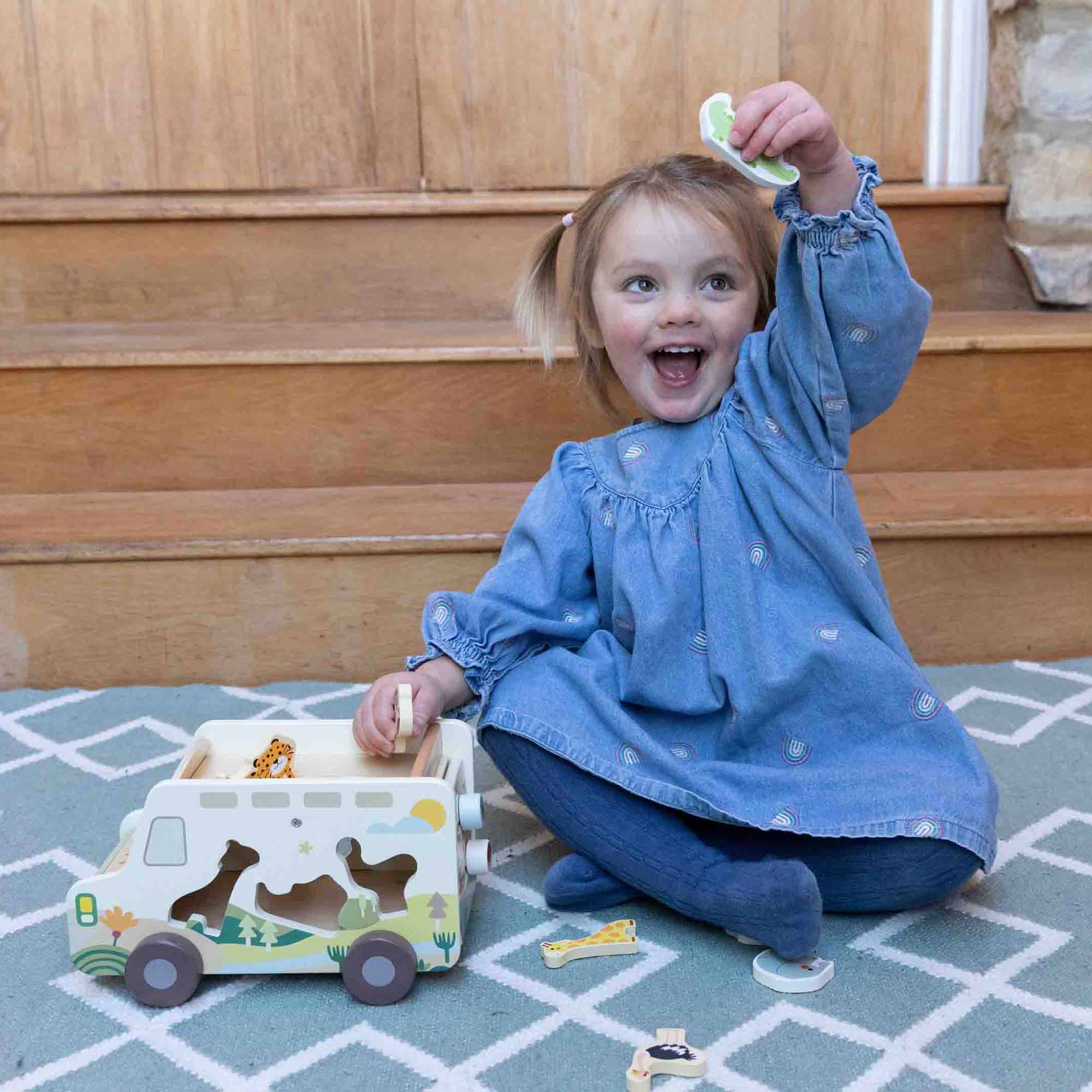 Little girl holding animal piece up from the Prairie Adventurer Truck