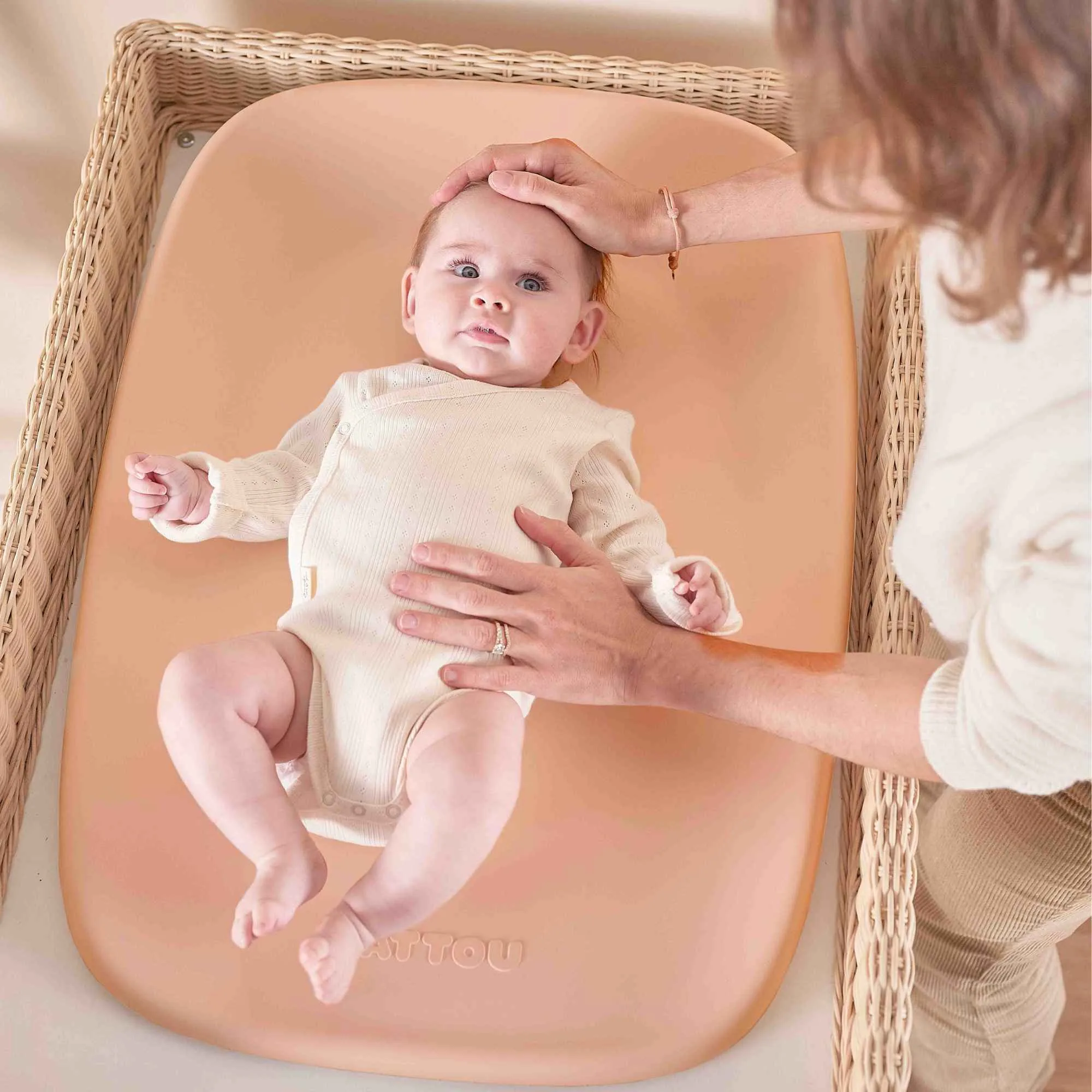 Baby lying on the Nattou Softy Peach