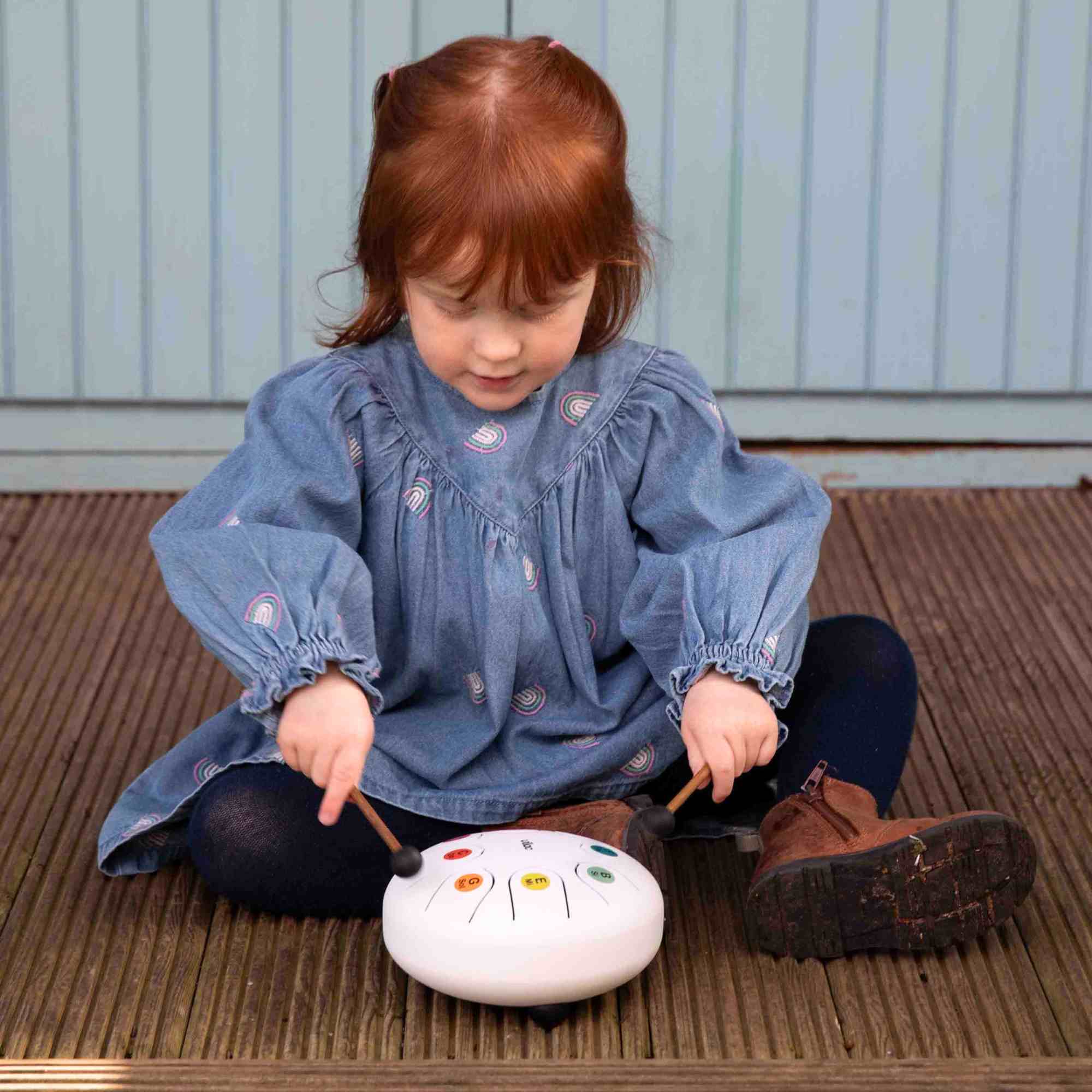 Little girl playing with the Tongue Drum