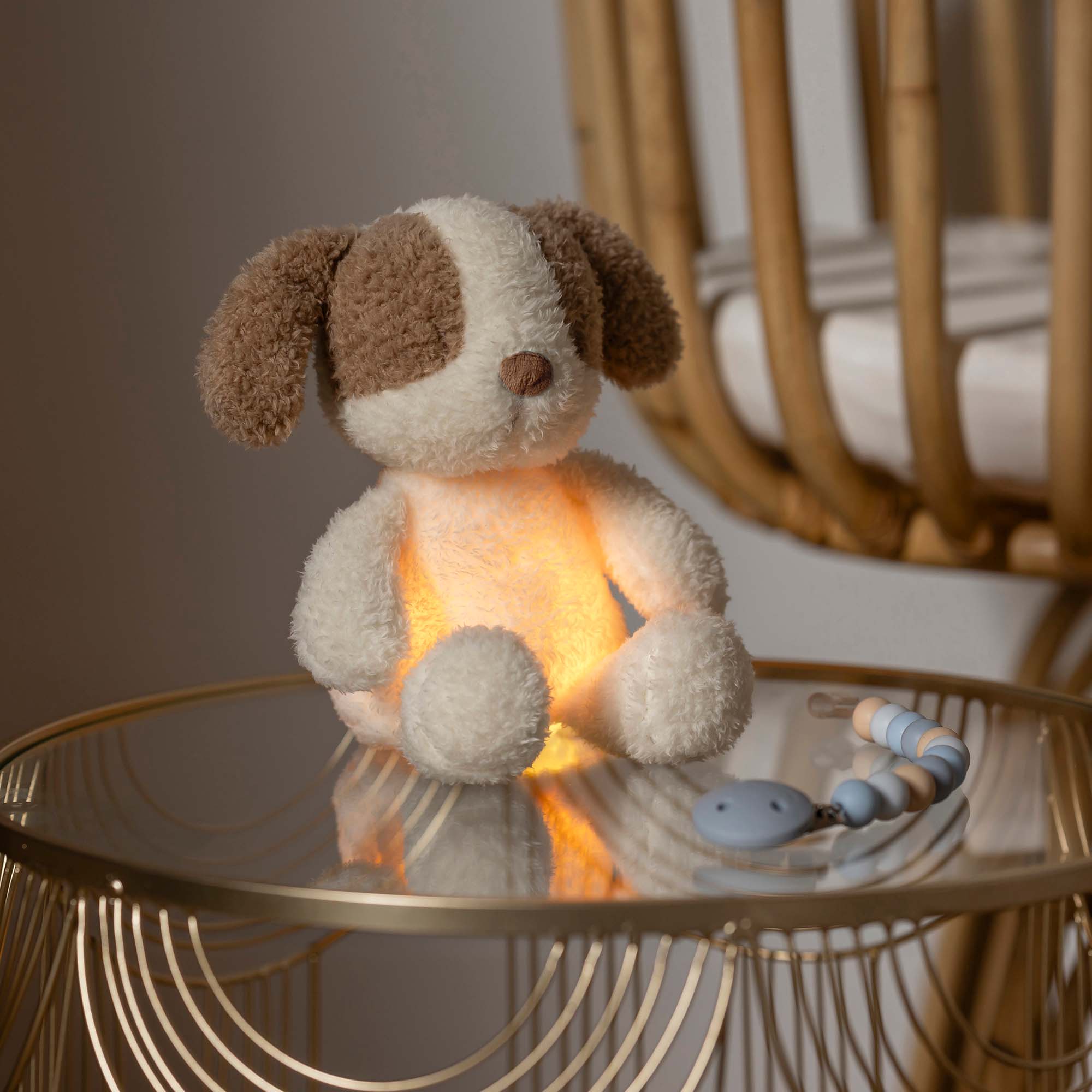 Dog Cuddly Nightlight on a table with the warm yellow light on