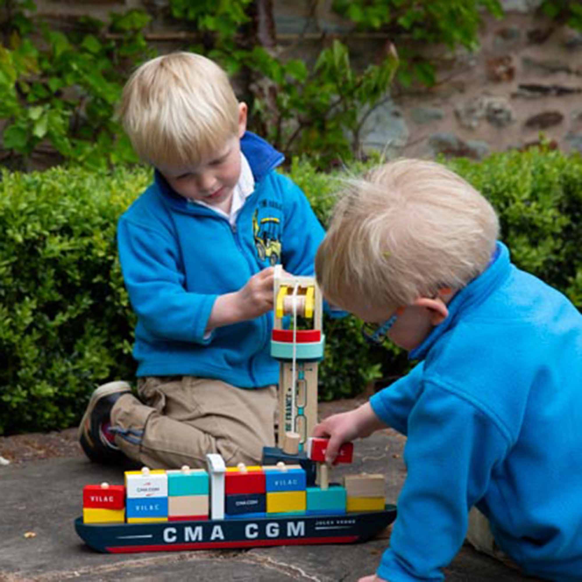 Boy playing with the Jacques Saade Container Ship and the Crane